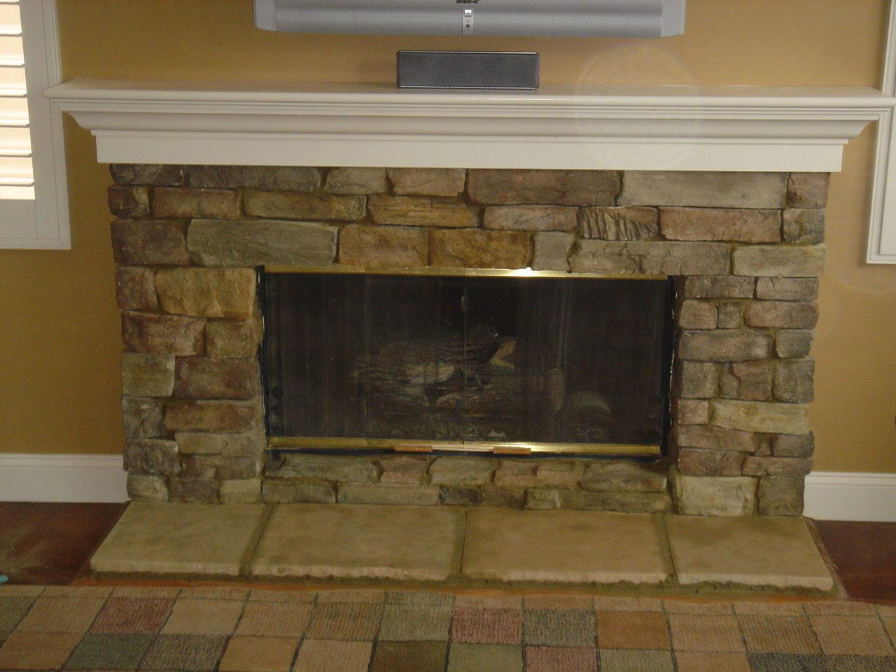 Refinished stone fireplace surround with white mantel