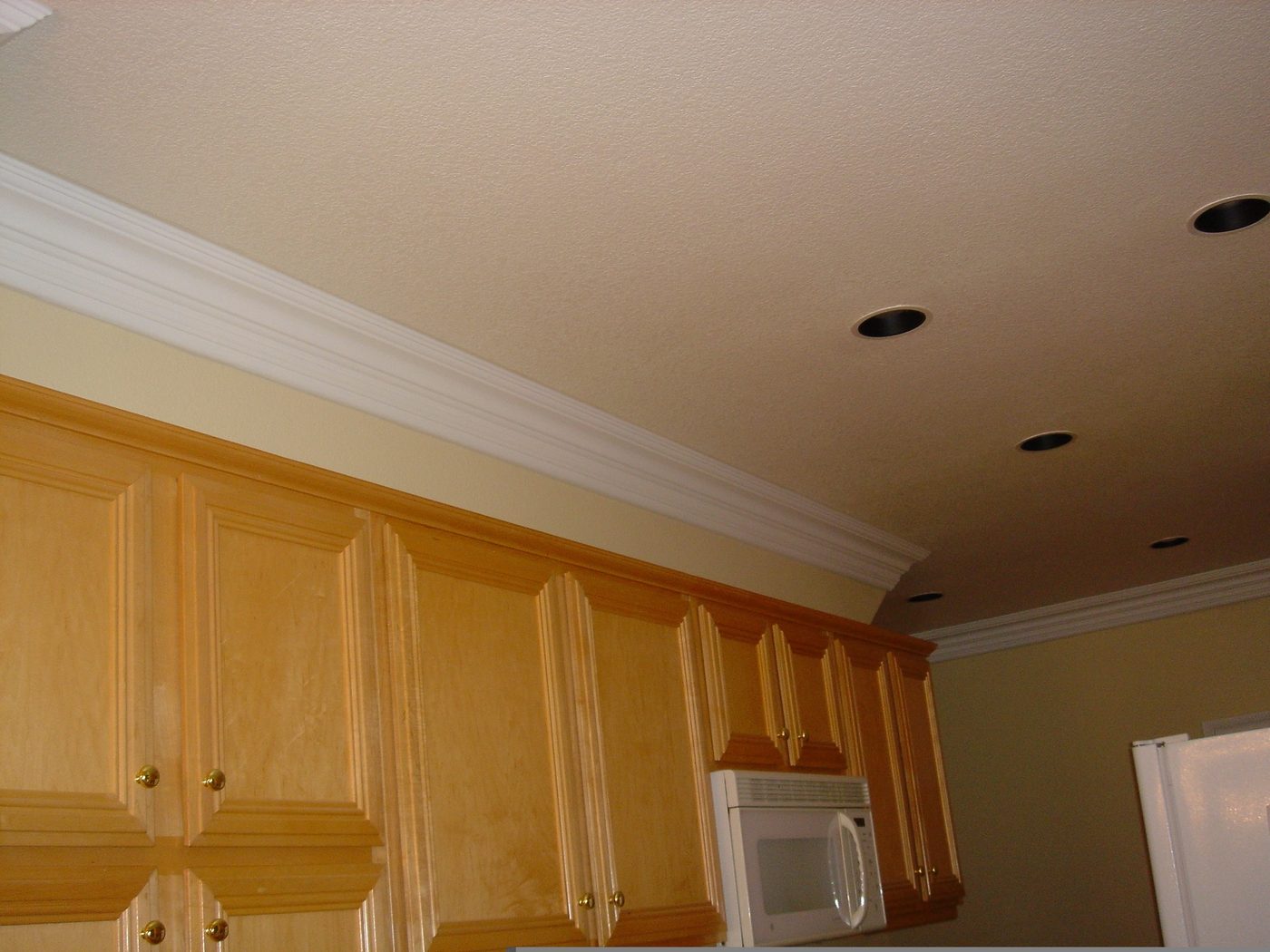 Kitchen with new crown molding, recessed lighting, and freshly painted cabinetry