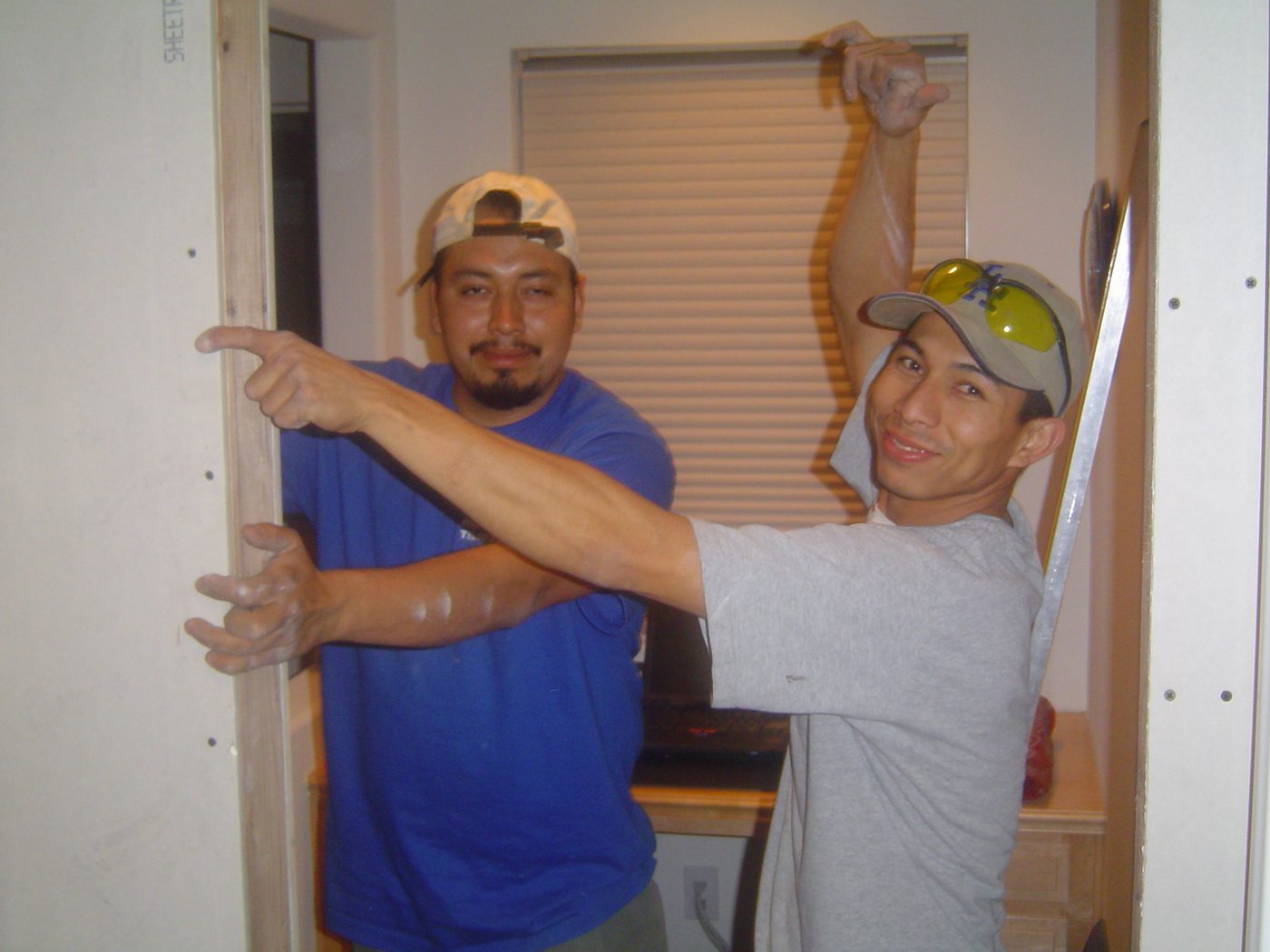 Two JV Home Repair technicians installing new drywall around a door frame